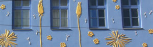 Die blaue Hausfassade der Butterblume mit goldenen Elementen.