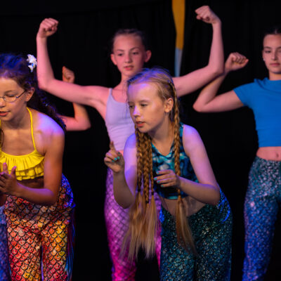 Mädchen choreografieren gemeinsam einen Tanz in bunten Outfits