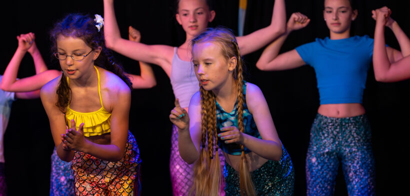 Mädchen choreografieren gemeinsam einen Tanz in bunten Outfits