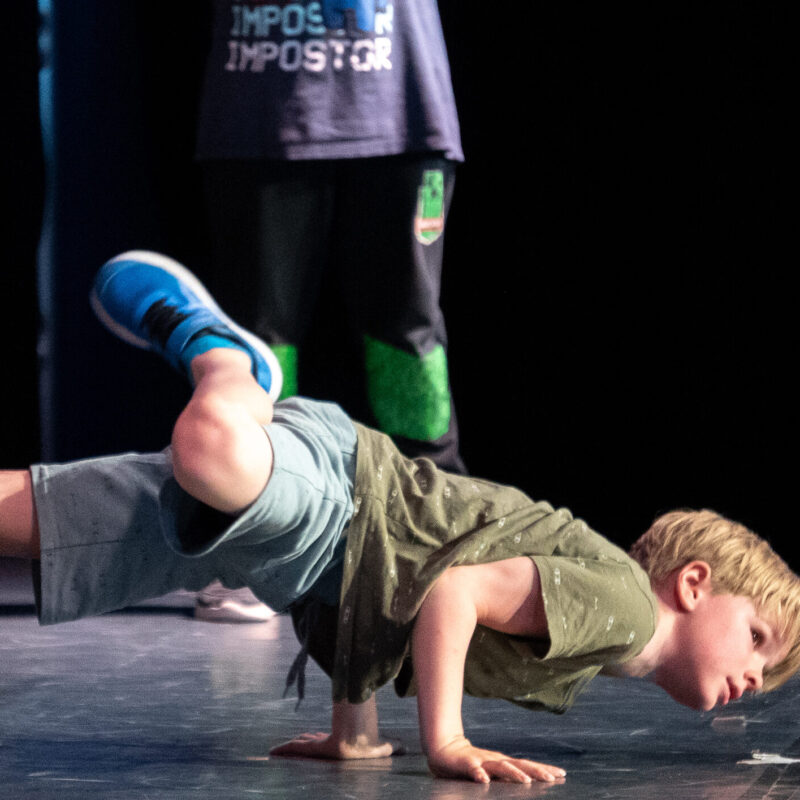 Ein Junge zeigt einen Breakdancemove am Boden