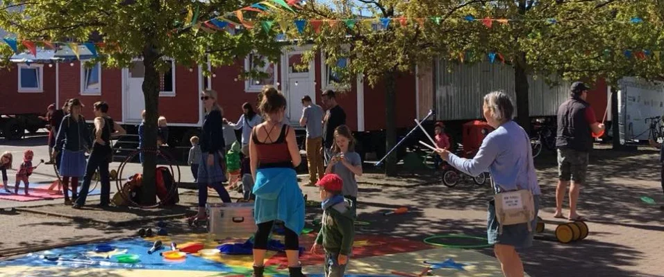 Kinder und Erwachsene stehen auf dem Platz des Circus Fantasia und probieren verschiedene Circusdisziplinen aus.